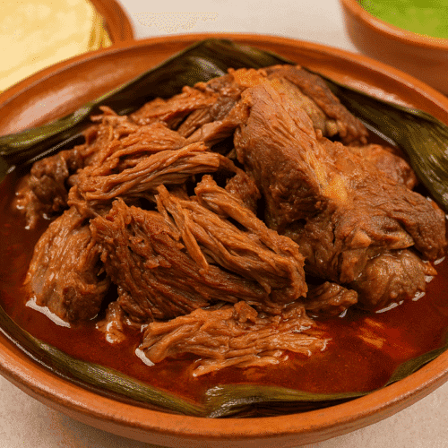 Barbacoa de Borrego slow-cooked lamb served in a clay dish with rich broth
