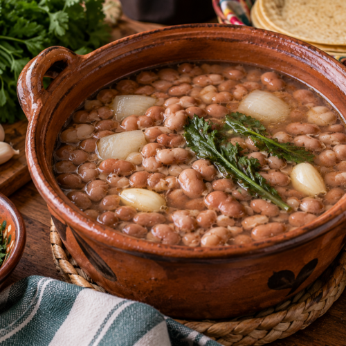 Frijoles de la olla with tender pinto beans, onion, garlic, and fresh herbs simmered in a traditional clay pot with warm corn tortillas.